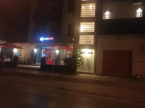 a building with a neon sign on it at night at London House in Bizerte