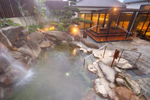 a swimming pool with a waterfall in a backyard at Nara Plaza Hotel in Tenri