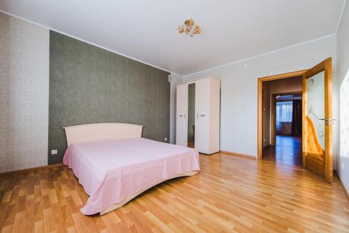 チタにあるDekabrist Apartment Tokmakova 36のウッドフロアのベッドルーム1室(白いベッド1台付)