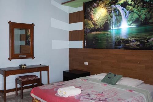 a bedroom with a bed with a painting on the wall at Pondok Bali Sea View Bungalow in Lovina