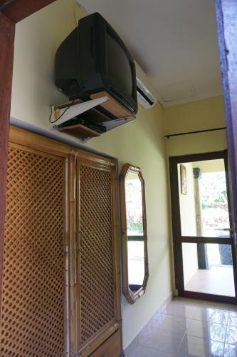 a flat screen tv hanging on the wall of a room at Pondok Bali Sea View Bungalow in Lovina