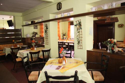 a dining room with two tables and chairs with flowers at Haus Kehrwieder - Hotel am Kur-Café in Bad Suderode