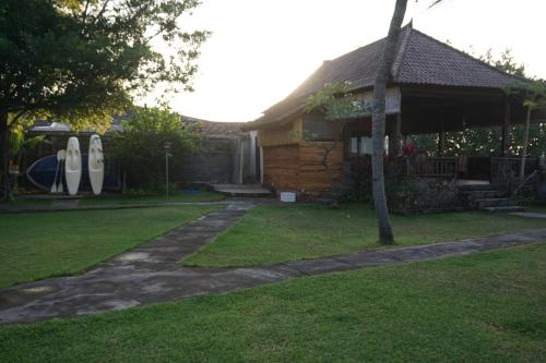 a house with a yard with a house with surfboards at Pondok Bali Sea View Bungalow in Lovina