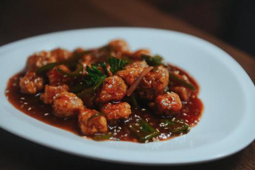 a white plate of food with meatballs and sauce at The Bricks Hotel in Dumaguete