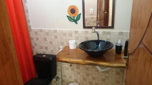 uma casa de banho com um lavatório preto e um WC. em Casa temporada na praia Joia do Atlântico - Ilhéus - Ba em Ilhéus