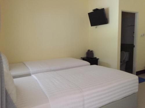 a bedroom with a white bed and a flat screen tv at Bannrommai Sattahip in Sattahip