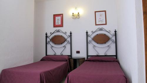 2 camas en una habitación con sábanas moradas en Bungalows Rebecca Park, en Playa del Inglés