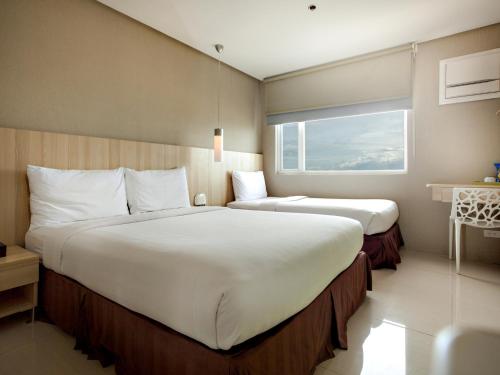 Postel nebo postele na pokoji v ubytování Injap Tower Hotel