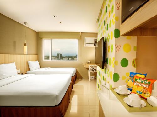 ein Hotelzimmer mit 2 Betten und einem Fenster in der Unterkunft Injap Tower Hotel in Iloilo City