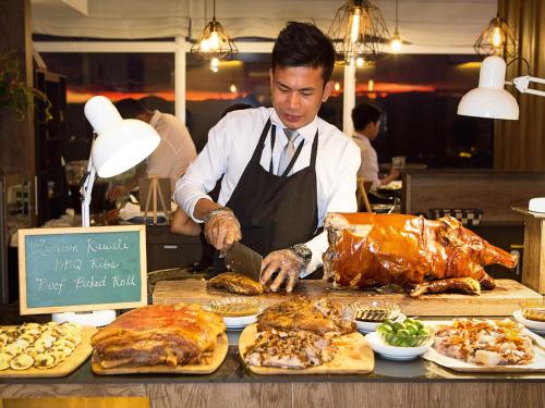 a man is preparing food in a kitchen at Injap Tower Hotel in Iloilo City