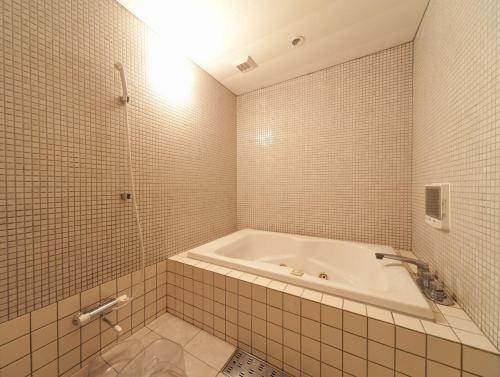 a white bathroom with a tub and a shower at Hotel Fine Shimane Matsue (Adult Only) in Matsue