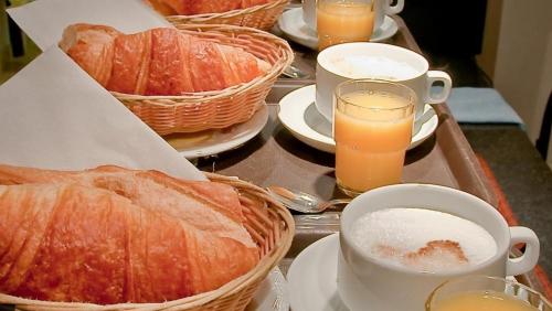 a table topped with baskets of bread and glasses of orange juice at Mary's Hotel République in Paris