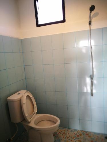 a bathroom with a toilet and a window at Smiley frog in Kanchanaburi City