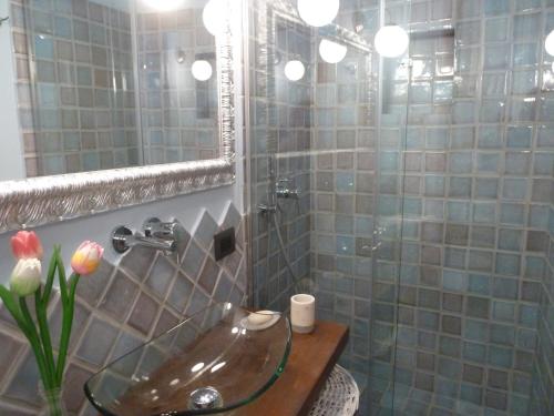 La salle de bains est pourvue d'un lavabo en verre et d'une douche. dans l'établissement Casa Orefici, 4 Apartments in front of Aquarium!, à Gênes