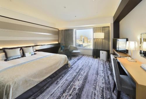 a hotel room with a bed and a desk at Hotel Granvia Okayama in Okayama