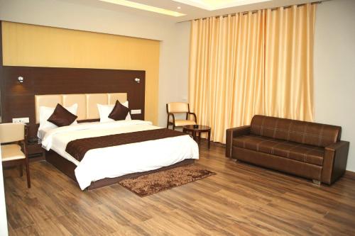 een slaapkamer met een groot bed en een bank bij Hotel Lavanya Palace in Ratlām