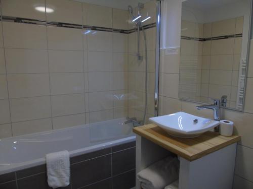 Chamouilley的住宿－Auberge du Cheval Blanc Logis，浴室配有盥洗盆和浴缸。