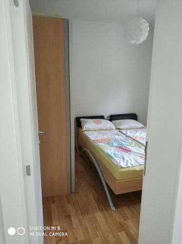 a small bedroom with a bed in a room at Apartments Nogic in Peroj