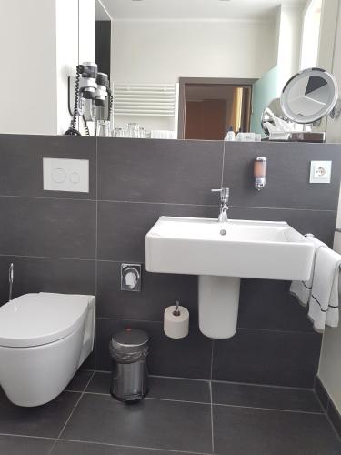 a bathroom with a white sink and a toilet at Hotel Hafenresidenz Stralsund in Stralsund