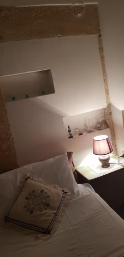 a bedroom with a bed with a lamp on a table at La Culla di Adeodata in Marsala