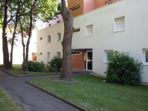 un bâtiment blanc avec un arbre dans l'herbe dans l'établissement Allee De Limoge, à Vannes