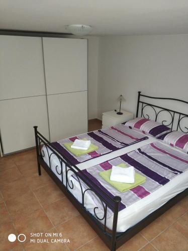 a bedroom with a large bed with a black frame at Apartments Nogic in Peroj
