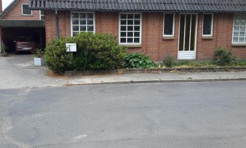 an empty street in front of a brick house at Indkvartering Filskov in Grindsted
