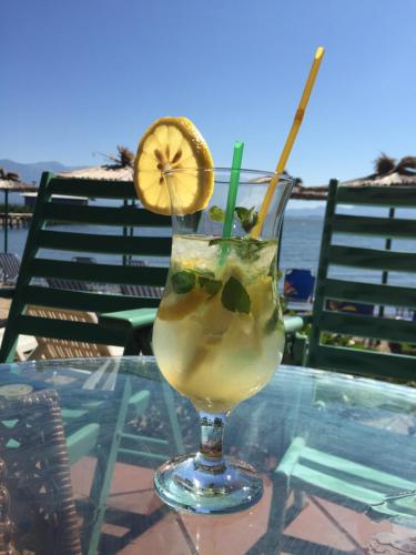 a drink on a table with a lemon slice in it at Apartmani Alex Beach in Star Dojran