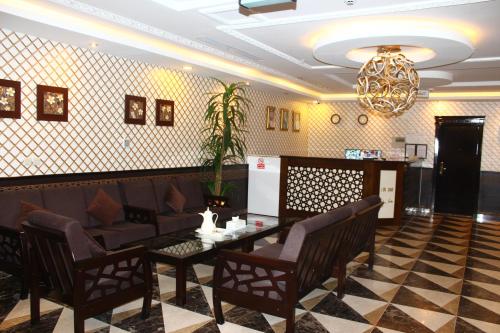 a restaurant with a table and chairs and a chandelier at Marina Hotel in Rayyis