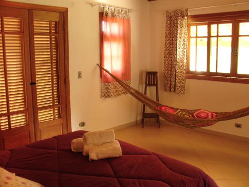 a hammock in a bedroom with a bed at Chalés de Valfena in São Francisco Xavier