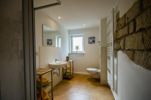 een badkamer met een wastafel, een toilet en een raam bij Ferienwohnung an der Habe in Bad Schandau