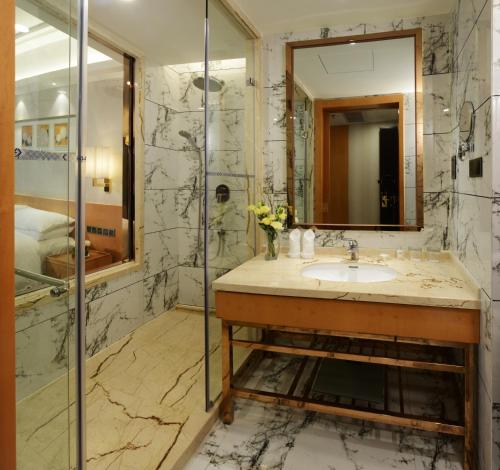 een badkamer met een wastafel en een spiegel bij Menshine Gloria Plaza Hotel in Shantou