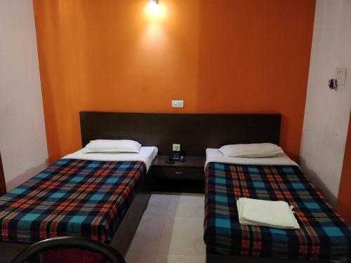 duas camas sentadas uma ao lado da outra num quarto em Hotel Empire em Guwahati
