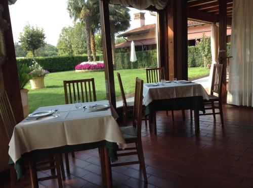 two tables and chairs in a room with a garden at Hotel Antica Fenice in Campalto