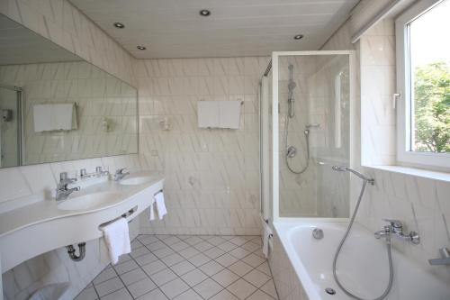 a bathroom with a sink, toilet and bathtub at Hotel Leopold in Munich