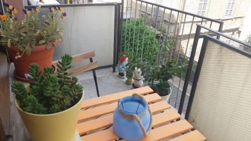 a wooden bench sitting on a balcony with potted plants at Le stanze di Bruno in Pescara