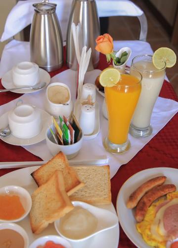 Ein Tisch voller Teller mit Frühstücksspeisen und Getränken in der Unterkunft Haile Resort Arbaminch in Migie