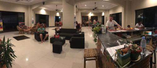 a lobby with people sitting in chairs and a bar at Blue Diamond Hostel in Battambang