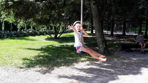 a young girl sitting on a pole in a park at Apartment Ulrich in Jablonec nad Jizerou