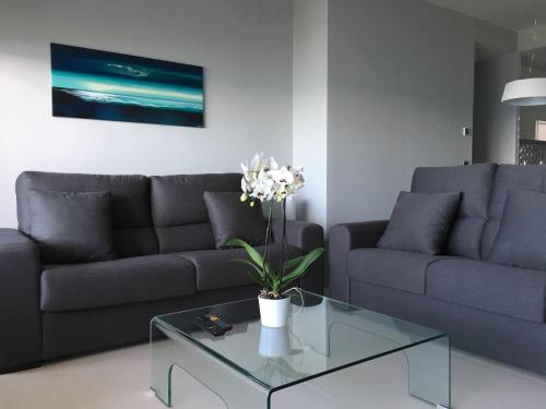 a living room with a couch and a glass coffee table at Sunset Drive Vistas Magicas in Benidorm