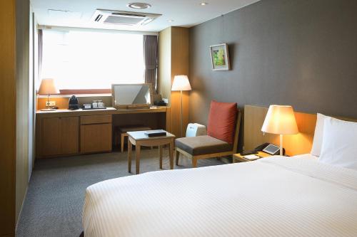 a hotel room with a bed and a desk at Hotel PJ Myeongdong in Seoul