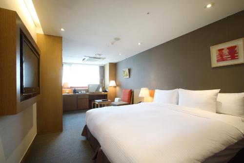 a hotel room with a bed and a television at Hotel PJ Myeongdong in Seoul