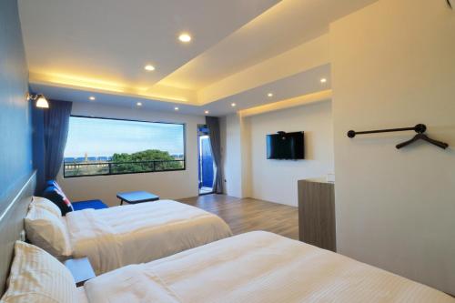 a hotel room with two beds and a large window at Two Home Inn in Hualien City