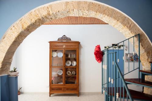 an archway in a room with a wooden cabinet at L' Arena Suite - Sicilian style 140 mq flat with balcony and Arena seeview in Castellammare del Golfo