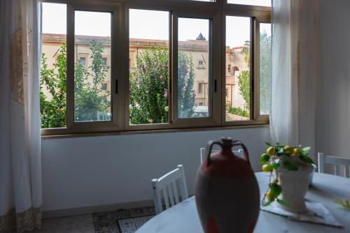 a table with a vase on a table in front of a window at L' Arena Suite - Sicilian style 140 mq flat with balcony and Arena seeview in Castellammare del Golfo