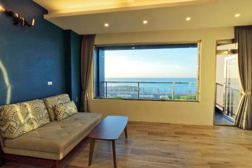 a living room with a couch and a large window at Two Home Inn in Hualien City