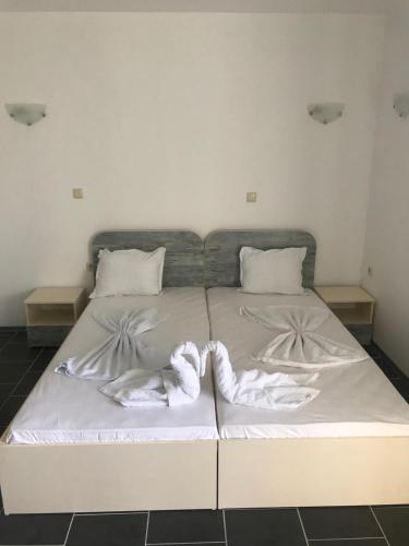 un letto bianco con due paia di asciugamani sopra di Limani Guest house a Sozopol