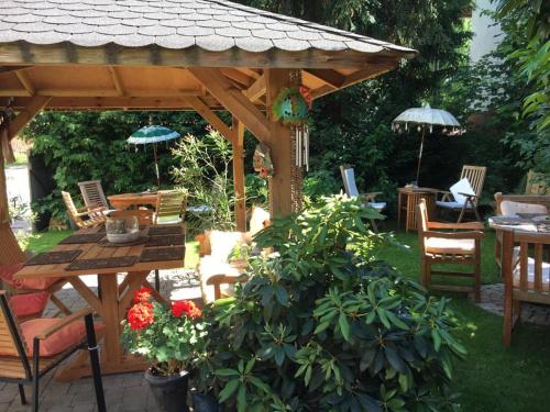 een houten prieel met een tafel en stoelen in een tuin bij Tektona "Bed & Breakfast" in Nidda