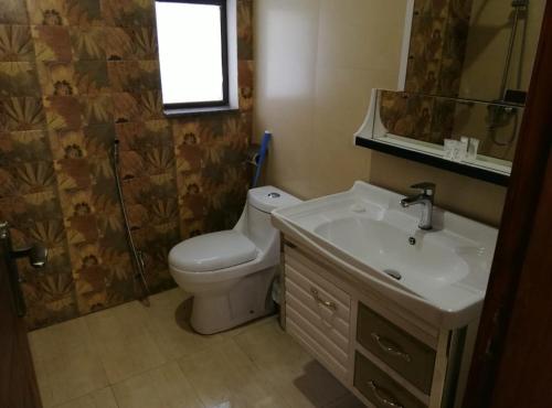 a bathroom with a toilet and a sink at Al-Fateh Hotel in Lahore