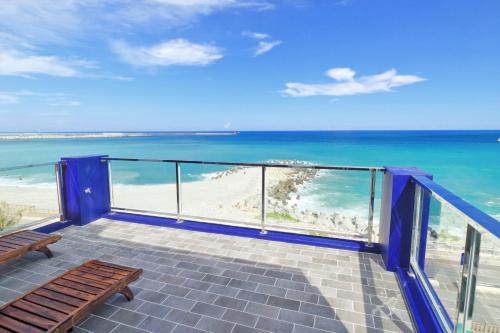 a balcony with a view of the beach and the ocean at Two Home Inn in Hualien City